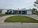 Charming blue home with a well-manicured lawn, brick driveway, and a one car garage at 12734 2Nd Isle, Hudson, FL 34667