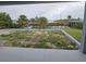 Backyard view showing pond and tropical trees at 14300 Kay Ln, Port Charlotte, FL 33981