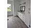 Bathroom with double sink vanity, bright window, and grey wood-look tile at 14300 Kay Ln, Port Charlotte, FL 33981