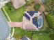 Aerial view of the home, highlighting the solar panels, screened pool, brick driveway, and well-maintained landscaping at 1508 Cascade Ct, Dunedin, FL 34698