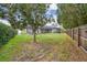 Expansive backyard featuring a screened-in lanai, mature trees, and a well-maintained lawn, perfect for outdoor activities at 1508 Cascade Ct, Dunedin, FL 34698