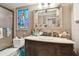 Charming bathroom with a stained glass window, decorative mirror, and vanity with ample storage at 1508 Cascade Ct, Dunedin, FL 34698