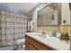 Bathroom features a stylish mirror, a vanity with sink, and a shower with a beach-themed curtain at 1508 Cascade Ct, Dunedin, FL 34698