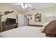 Bedroom with light yellow walls, a ceiling fan, a TV, and a door to the rest of the house at 1508 Cascade Ct, Dunedin, FL 34698