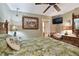 Bedroom with wicker furniture, tropical bedding, a TV, and access to an ensuite bathroom at 1508 Cascade Ct, Dunedin, FL 34698