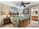 Bedroom featuring tropical-themed decor, a ceiling fan, and access to an ensuite bathroom at 1508 Cascade Ct, Dunedin, FL 34698