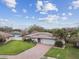 Aerial view of the front exterior showcasing a well-manicured lawn, brick driveway, and a home with solar panels at 1508 Cascade Ct, Dunedin, FL 34698