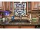 Close-up of kitchen sink area featuring granite countertops and custom backsplash at 1508 Cascade Ct, Dunedin, FL 34698