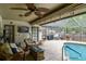 The covered patio features seating space, a ceiling fan, and access to an outdoor grilling area at 1508 Cascade Ct, Dunedin, FL 34698