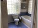 Bathroom featuring a glass block window, bathtub, and blue tiled floors at 16921 Crawley Rd, Odessa, FL 33556