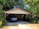 Covered carport with space for two vehicles, with a peek into the garage at 16921 Crawley Rd, Odessa, FL 33556