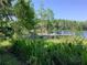 A serene dock extends into the lake, surrounded by lush greenery, perfect for relaxing by the water at 16921 Crawley Rd, Odessa, FL 33556