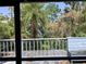 Enclosed porch featuring tropical tree view framed by a white wooden railing at 16921 Crawley Rd, Odessa, FL 33556
