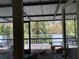 Enclosed porch with view of deck featuring white railing and tropical trees at 16921 Crawley Rd, Odessa, FL 33556
