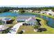 Breathtaking aerial view of a single-story home on the water featuring a brick driveway and manicured lawn at 1742 W Del Webb Blvd, Sun City Center, FL 33573