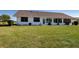 Backyard with large lawn, white home and enclosed sunroom at 1742 W Del Webb Blvd, Sun City Center, FL 33573