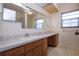 Bathroom with long vanity and marble-style countertop, cabinets and ceiling fan at 1742 W Del Webb Blvd, Sun City Center, FL 33573