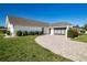 Charming single-story home with a brick driveway, manicured lawn, and attached garage at 1742 W Del Webb Blvd, Sun City Center, FL 33573