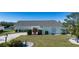 Charming single-story home features a well-manicured lawn, complemented by a brick driveway and lush landscaping at 1742 W Del Webb Blvd, Sun City Center, FL 33573