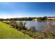 Scenic lake view showing the water, shoreline, trees and a white home at 1742 W Del Webb Blvd, Sun City Center, FL 33573