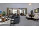 Spacious living room featuring neutral carpeting, stylish furniture, and sliding doors leading to patio at 1742 W Del Webb Blvd, Sun City Center, FL 33573