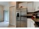 Stainless steel refrigerator and modern kitchen with stainless steel appliances and white cabinets at 17567 Nectar Flume Dr, Land O Lakes, FL 34638