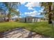Spacious backyard with a concrete pad, lush green grass, and mature shade trees at 1910 E Chelsea St, Tampa, FL 33610