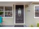 Elegant front door with decorative glass, flanked by windows and house number 1910 at 1910 E Chelsea St, Tampa, FL 33610