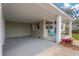 Charming front porch with brick columns, adjacent carport, and green and red plants at 1910 E Chelsea St, Tampa, FL 33610