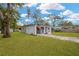 Well-maintained home with a green lawn, an American flag, and attractive landscaping at 1910 E Chelsea St, Tampa, FL 33610
