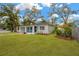 Charming home with an inviting covered porch, lush green lawn, and lovely curb appeal at 1910 E Chelsea St, Tampa, FL 33610