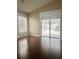 This bedroom features hardwood floors, a large window with custom blind and sliding glass doors to the screened lanai at 2015 Golf Manor Blvd, Valrico, FL 33596