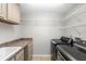 Laundry room with washer, dryer, sink, storage cabinets, and wire shelving at 2015 Golf Manor Blvd, Valrico, FL 33596