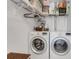 Efficient laundry room with a washer, dryer, and ample shelving for storage at 210 Fernwood Cir # 210, Seminole, FL 33777