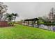 Landscaped backyard with grassy lawn and private dock on the canal at 22819 Southshore Dr, Land O Lakes, FL 34639