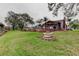 Beautiful backyard with green grass, mature trees, outdoor seating and a fire pit at 22819 Southshore Dr, Land O Lakes, FL 34639