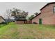 Spacious backyard showing the house exterior, shed, and lush green lawn, providing ample space for outdoor activities at 22819 Southshore Dr, Land O Lakes, FL 34639