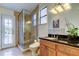 Well-lit bathroom featuring a glass-enclosed shower, black countertops, and wood cabinets at 22819 Southshore Dr, Land O Lakes, FL 34639