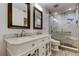 Bright bathroom featuring double sinks and a glass-enclosed shower with grab bar at 22819 Southshore Dr, Land O Lakes, FL 34639