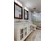 Bathroom with double sink vanity, framed mirrors, modern lighting, and a glass enclosed tile shower at 22819 Southshore Dr, Land O Lakes, FL 34639