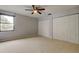A bright bedroom with a ceiling fan, neutral walls, and a double set of closets at 22819 Southshore Dr, Land O Lakes, FL 34639