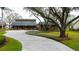 Charming home featuring a manicured lawn, mature tree, and long, inviting driveway at 22819 Southshore Dr, Land O Lakes, FL 34639