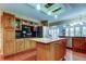 A spacious kitchen with an island, stainless steel refrigerator, and wood cabinets provides lots of storage at 22819 Southshore Dr, Land O Lakes, FL 34639