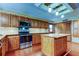 Spacious kitchen with wood cabinets, stainless steel appliances, and a brick floor at 22819 Southshore Dr, Land O Lakes, FL 34639