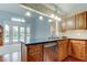 Open kitchen featuring wood cabinets, granite countertops, and stainless steel appliances with views to the backyard pool at 22819 Southshore Dr, Land O Lakes, FL 34639