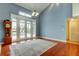 Living room featuring a high ceiling, hardwood floors, and french doors leading to an outdoor pool at 22819 Southshore Dr, Land O Lakes, FL 34639