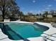 Backyard pool overlooking the lake surrounded by well-maintained greenery under a blue, partly cloudy sky at 22819 Southshore Dr, Land O Lakes, FL 34639