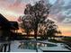 Backyard pool view at dusk, featuring a deck, waterfront view, and serene ambiance for relaxation at 22819 Southshore Dr, Land O Lakes, FL 34639