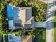 Aerial view of home with solar panels, manicured landscaping, and swimming pool in a private backyard setting at 2370 Jones Dr, Dunedin, FL 34698