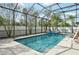 Enjoy this screened pool offering a tranquil outdoor retreat with a waterfall, in-ground spa and travertine decking at 2515 Sherman Oak Dr, North Port, FL 34289